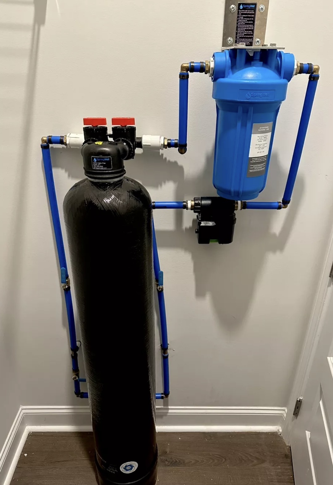SpringWell whole-home carbon filter and pre-filter installed with blue PEX lines