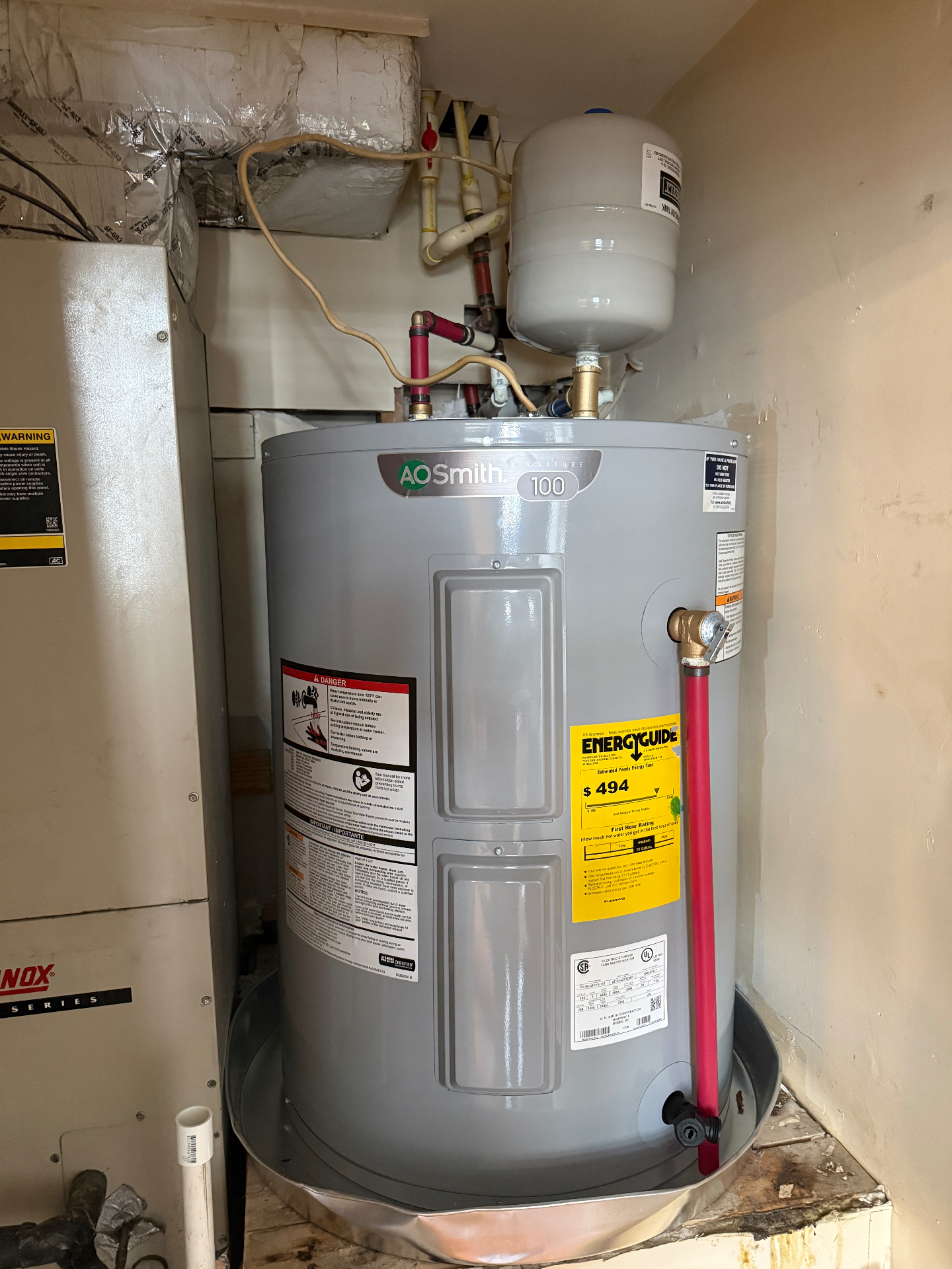 Installed AO Smith water heater with expansion tank in a utility closet